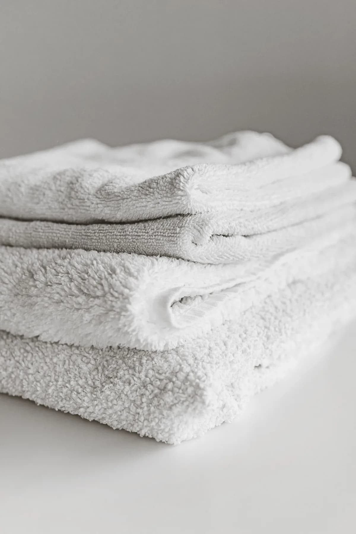 Freshly laundered bedding and towels folded and stacked, ready for an Airbnb property in Cardiff