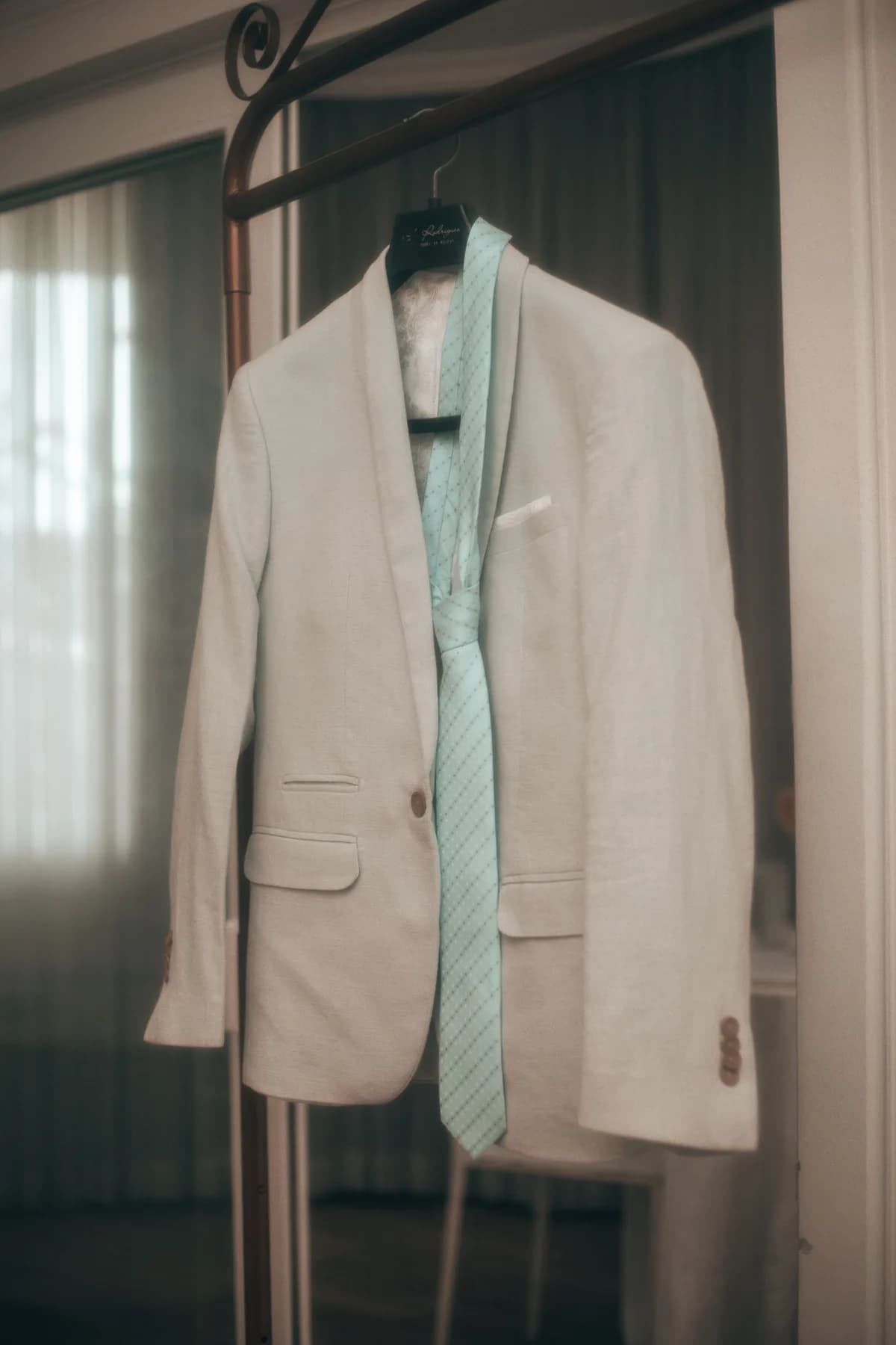 A well-pressed suit jacket on a wide wooden hanger, showing correct suit storage and care between wears in Cardiff